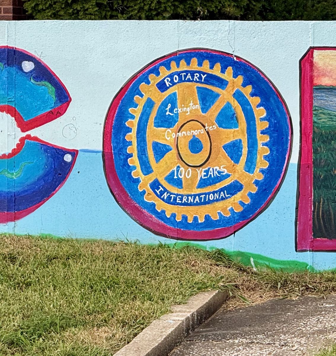 WELCOME mural with a Rotary Lexington 100 Years wheel painted into the letter O